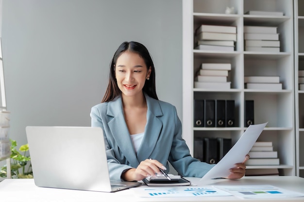 写真 young happy businesswoman using computer in office stylish beautiful manager smiling working on financial and marketing projects portrait of a young businesswoman working on a laptop in an office