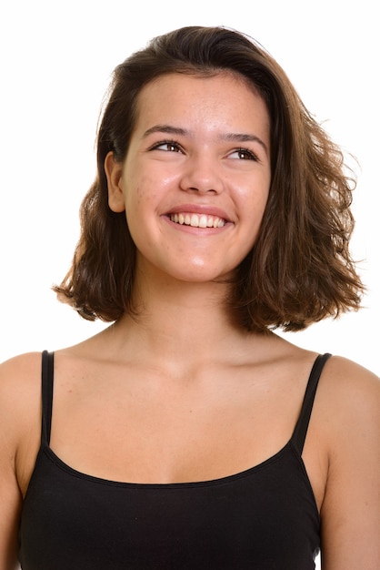 Young happy Caucasian teenage girl smiling and thinking isolated on white