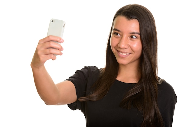 Young happy Caucasian woman smiling and taking selfie with mobile phone