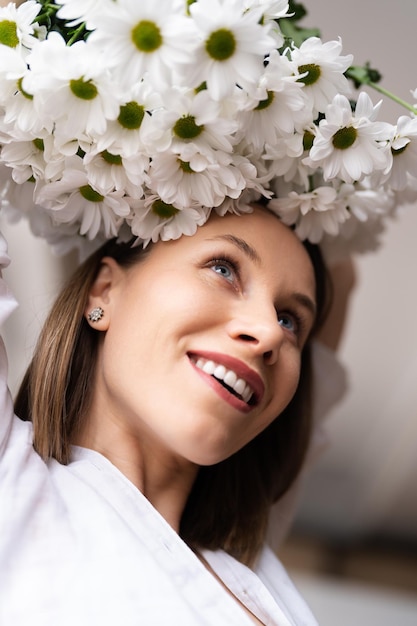 Young happy cheerful sweet lovely smiling woman enjoy a bouquet of white fresh flowers