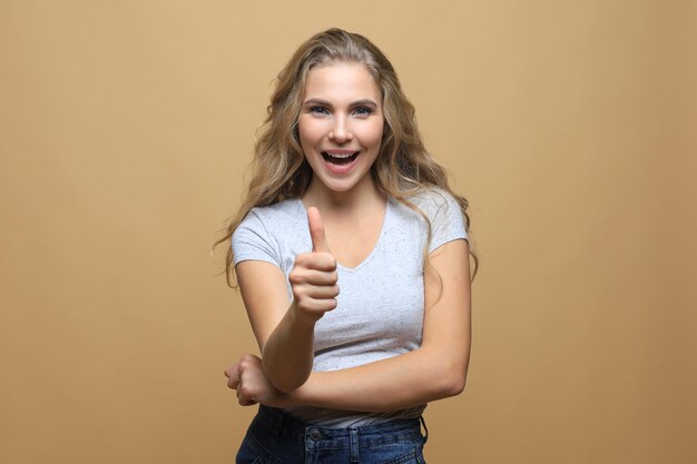 Young happy cheerful woman showing thumb up.