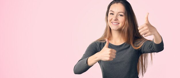 Young happy cheerful woman showing thumb up