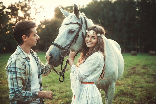 Young happy couple and beautiful horse