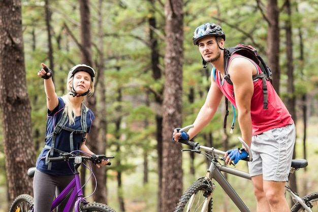 Young happy couple on bikes looking away