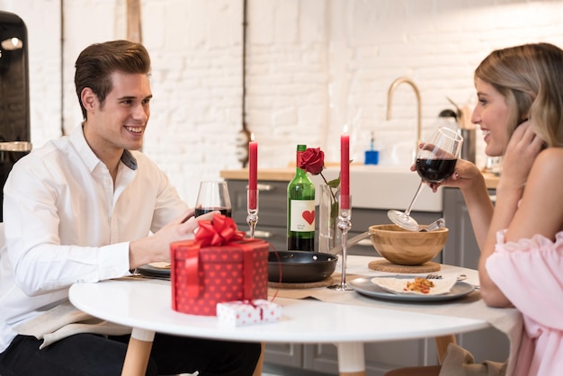 Young happy couple celebrating Valentine's day with a dinner at home