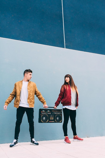 Young happy couple dancing on the street with a vintage radio cassette stereo xA