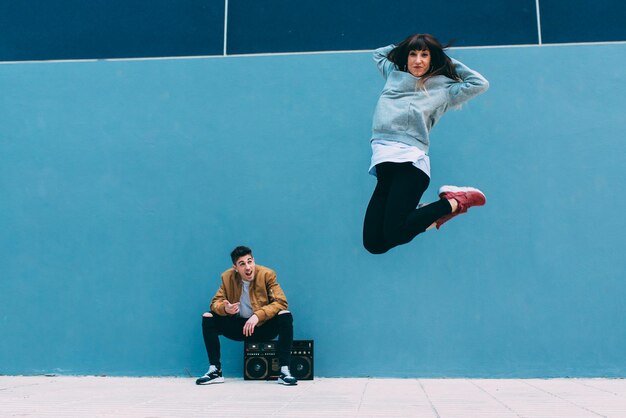 Young happy couple dancing on the street with a vintage radio cassette stereo xA