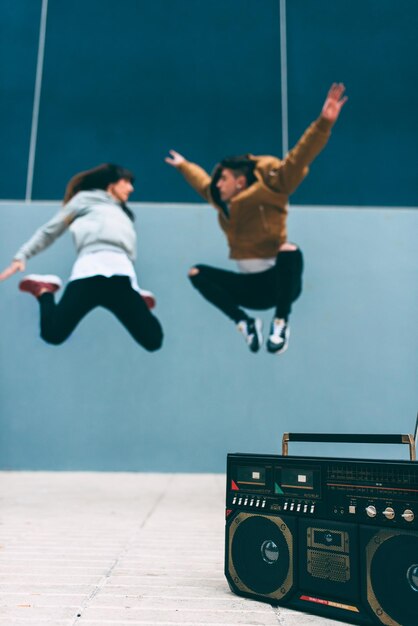 Young happy couple dancing on the street with a vintage radio cassette stereo xA