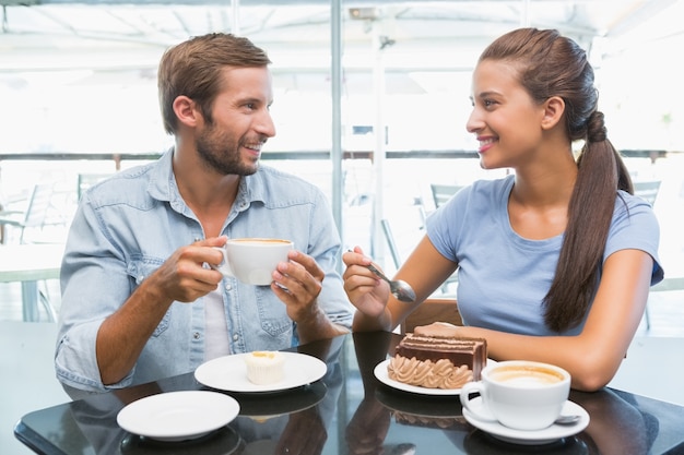 Young happy couple eating cake 