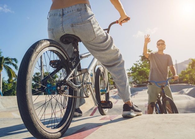 Молодая счастливая пара наслаждается катанием на BMX в скейтпарке