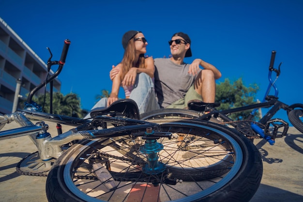 Photo young happy couple enjoy bmx riding at the skatepark