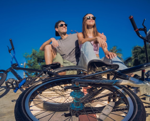 Foto una giovane coppia felice si diverte a guidare la bmx allo skatepark