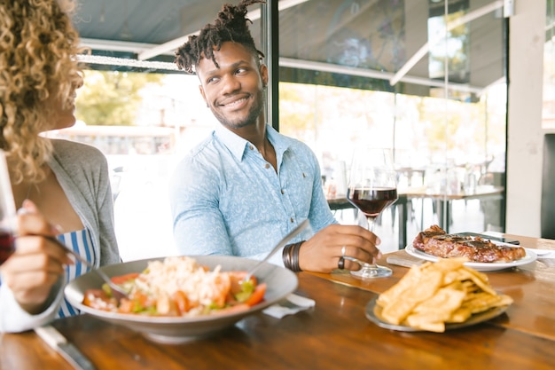 Young happy couple enjoying together while on a date at a restaurant.