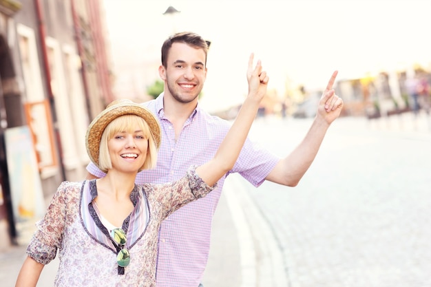 young happy couple hailing a taxi in a city