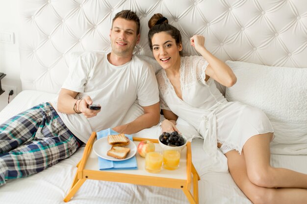 Young happy couple having breakfast in luxury room