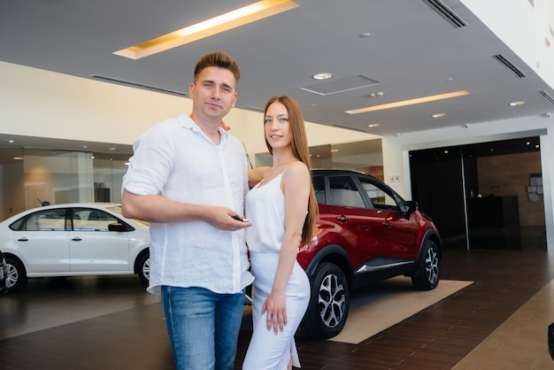 A young happy couple is happy to buy a new car. Car purchase.