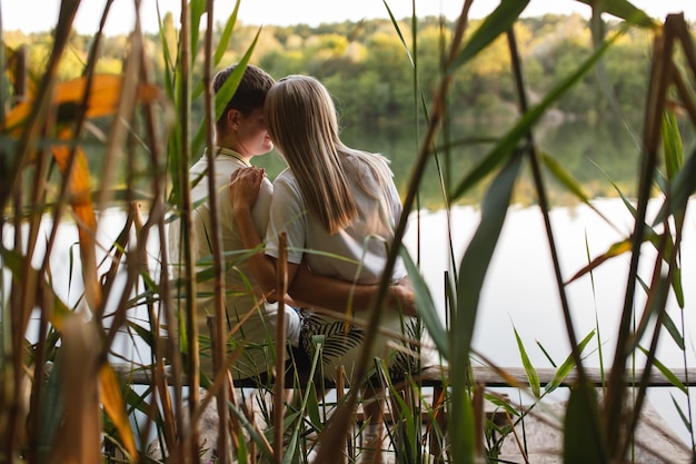 Giovane coppia felice innamorata che abbraccia e bacia sullo sfondo della natura uomo e donna in un appuntamento romantico