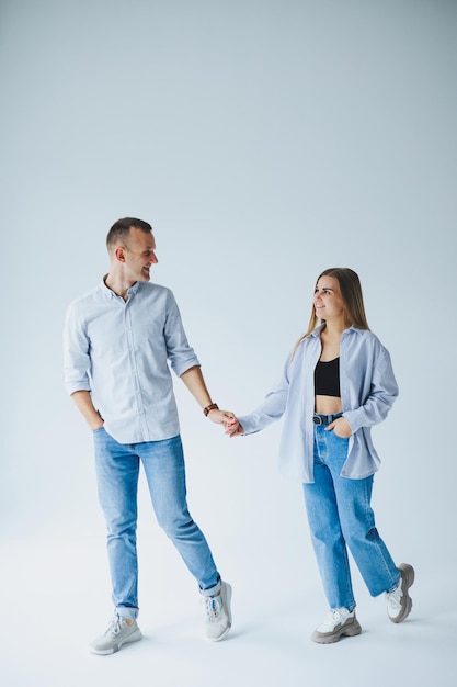 Young happy couple in love in jeans and shirts on a white background Smiling romantic man and woman