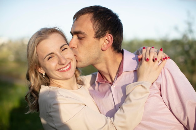 Young happy couple in love outdoors loving man and woman on a walk in a spring blooming park