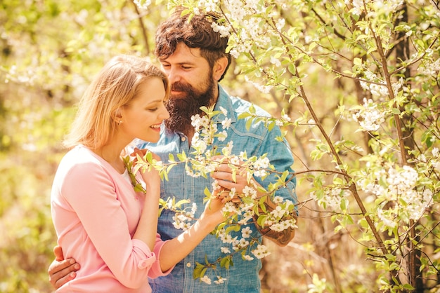 Giovani coppie felici nell'amore all'aperto. coppia romantica innamorata che sente felicità. ritratto di giovane coppia sorridente sullo sfondo del fiore di primavera. buona pasqua.