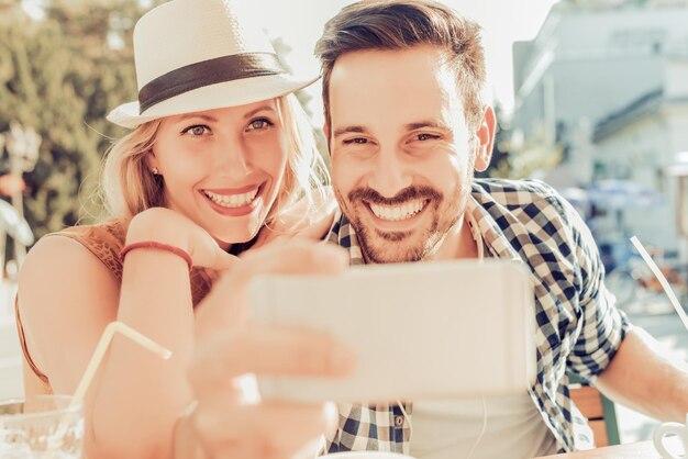 Young happy couple making a selfie in the cafe