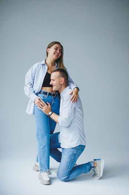 Giovani coppia felice uomo e donna si rallegrano e si abbracciano giovane famiglia sorridente su uno sfondo bianco