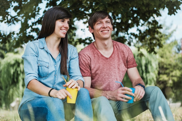 Young happy couple relaxing in the shade of a tree