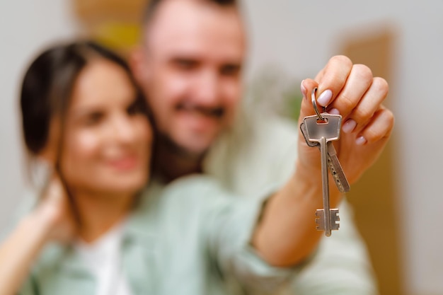 Young happy couple in room with moving boxes at new home