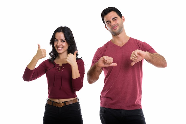 young happy couple smiling with woman giving thumbs up and man giving thumbs down