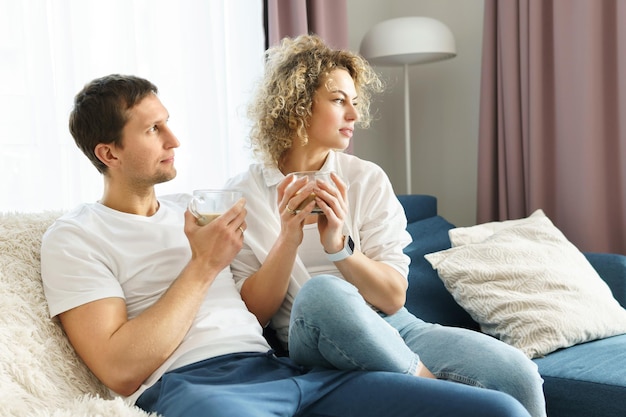 Young happy couple spending time together and drinking coffee at home