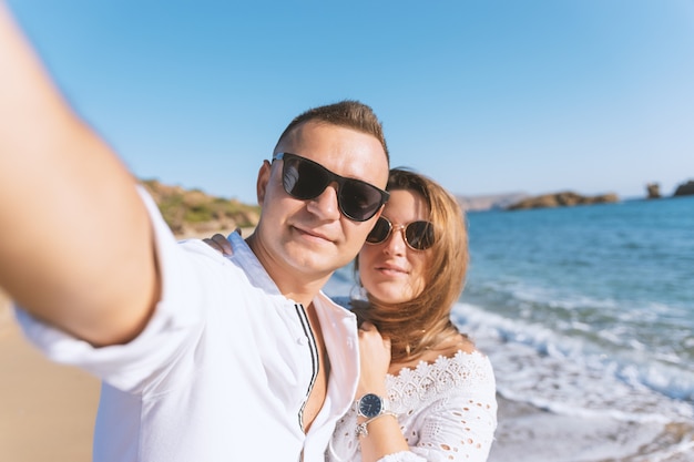 Young happy couple taking selfie on the beach