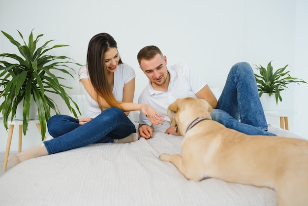 家に座っている犬と若い幸せなカップル