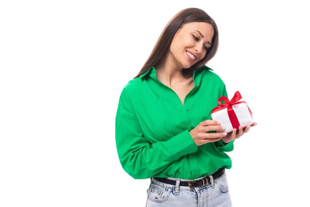 Фото Молодая счастливая европейская брюнетка с карими глазами в зеленой блузке получила от нее подарок
