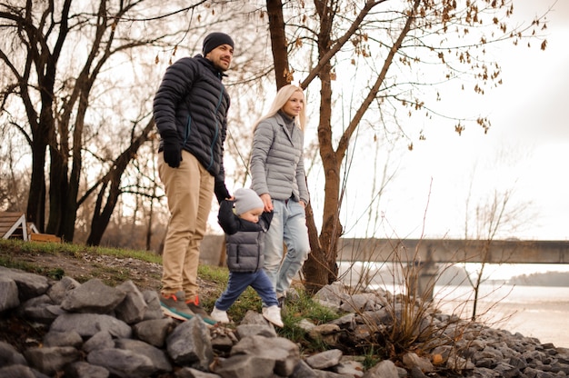 Young and happy family couple walking with the son