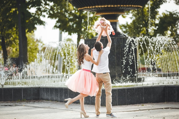 Молодая счастливая семья возле фонтана