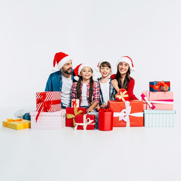 Giovane famiglia felice in cappelli della santa con i regali di natale