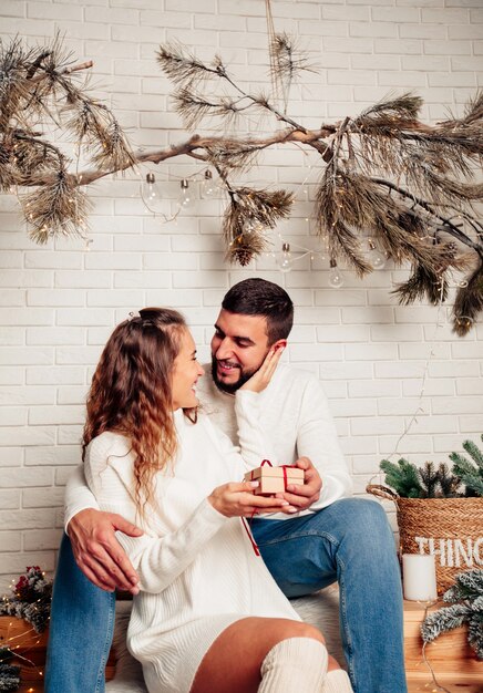 young happy family sitting in an embrace with a gift in their hands