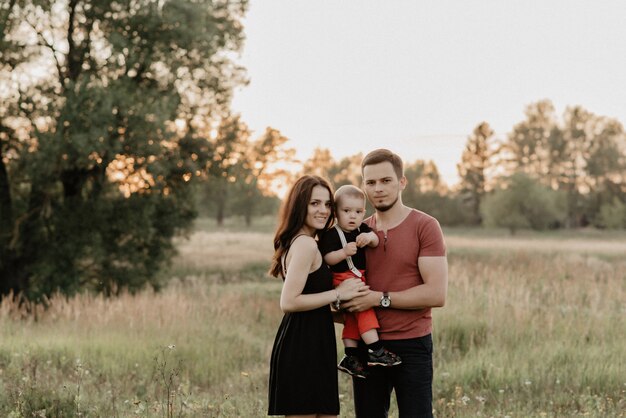 Young happy family in summer in the field