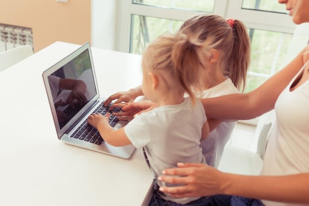 Foto giovane famiglia felice che usa il laptop mentre è seduto in cucina a casa