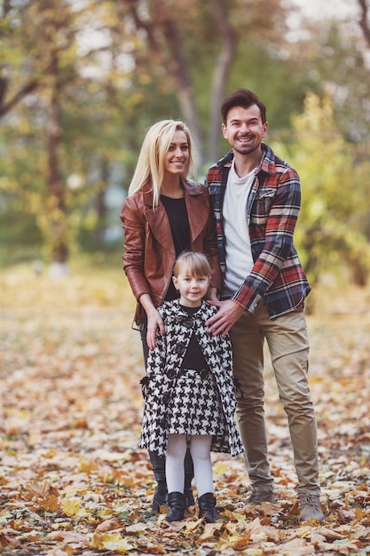 Young happy family while walking in the autumn park