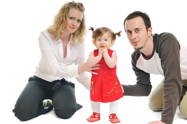 Foto giovane famiglia felice con bellissimo bambino che gioca e sorride isolato su bianco in studio