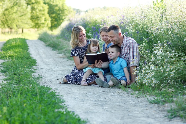 Giovane famiglia felice con bambini che leggono la bibbia