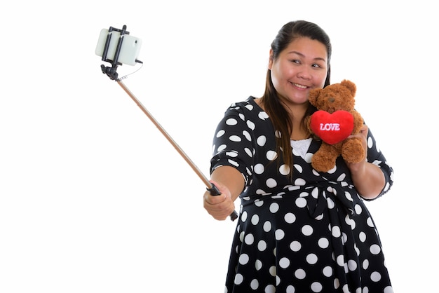 Photo young happy fat asian woman smiling while taking a selfie