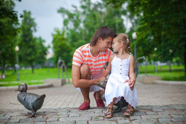 Молодой счастливый отец с дочерью в парке весело