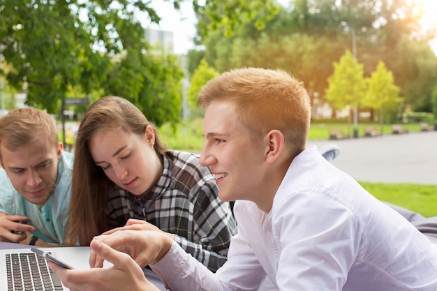 Young happy friends have a rest in the park in summer day.