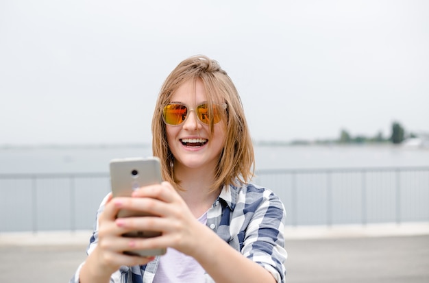 hipster 전화 selfie를 만드는 젊은 행복 한 소녀.