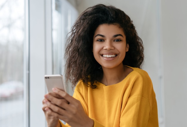 Young happy girl holding smartphone