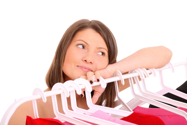 a young happy girl surrounded by clothes over white