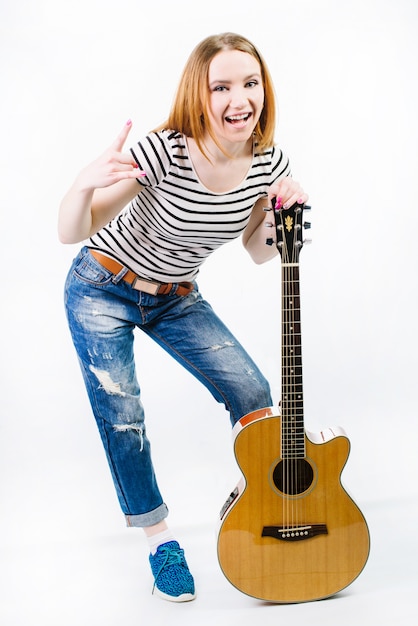 Young happy girl with acoustic guitar on white