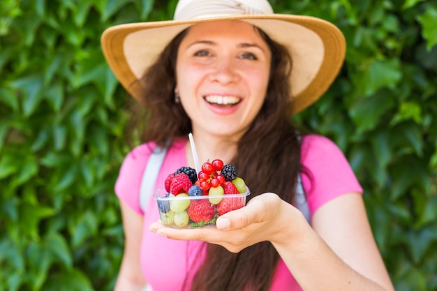 Молодая счастливая девушка со свежими ягодами на открытом воздухе